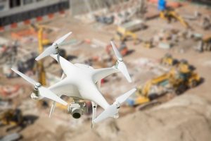 UAV quadcopter flying over a construction site in order to film a documentary of a construction company