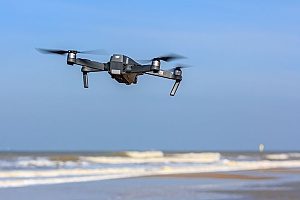 a ground shot of the beach where a drone equipped with drone insurance is capturing footage of the beach near Los Angeles, CA