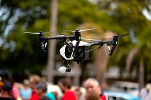 drone that is covered by drone insurance monitoring a crowd of people at an event 