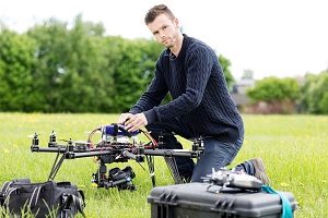 photographer setting up his camera on a drone that is covered by drone insurance 